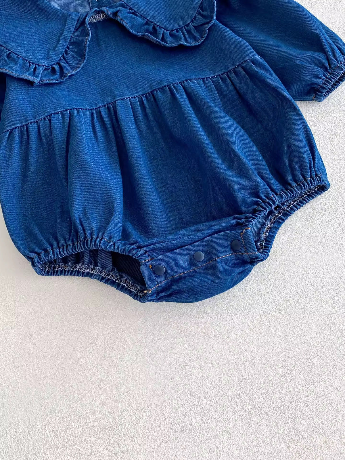 Close-up of bubble legs on denim baby romper