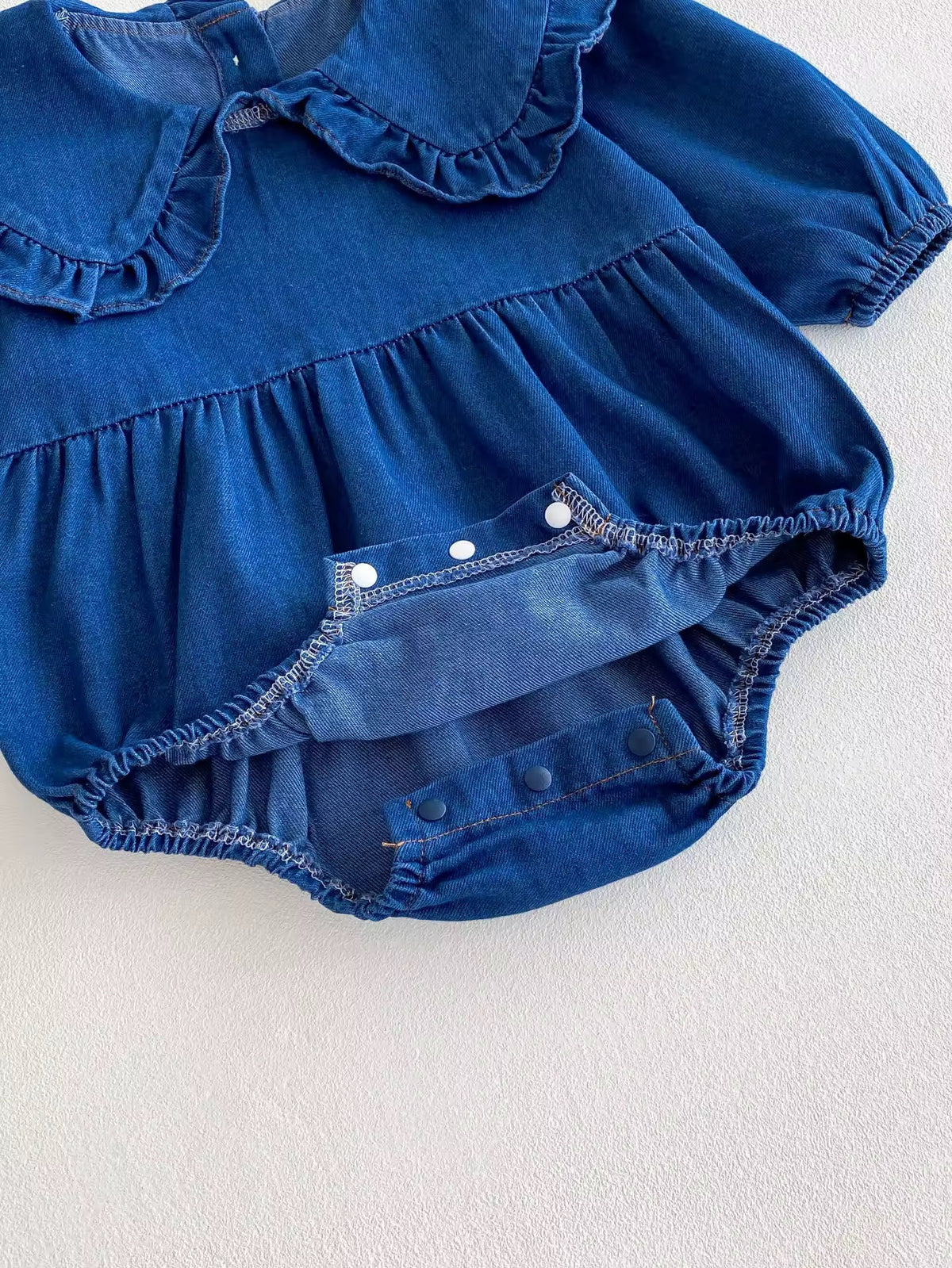 Snap crotch closure on denim baby romper