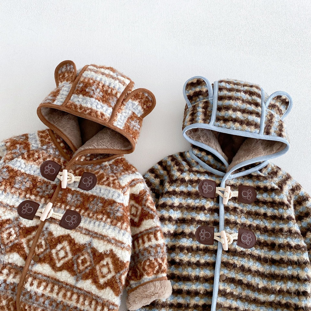 Close-up of the bear-ear hoods and toggle fastenings on both coats