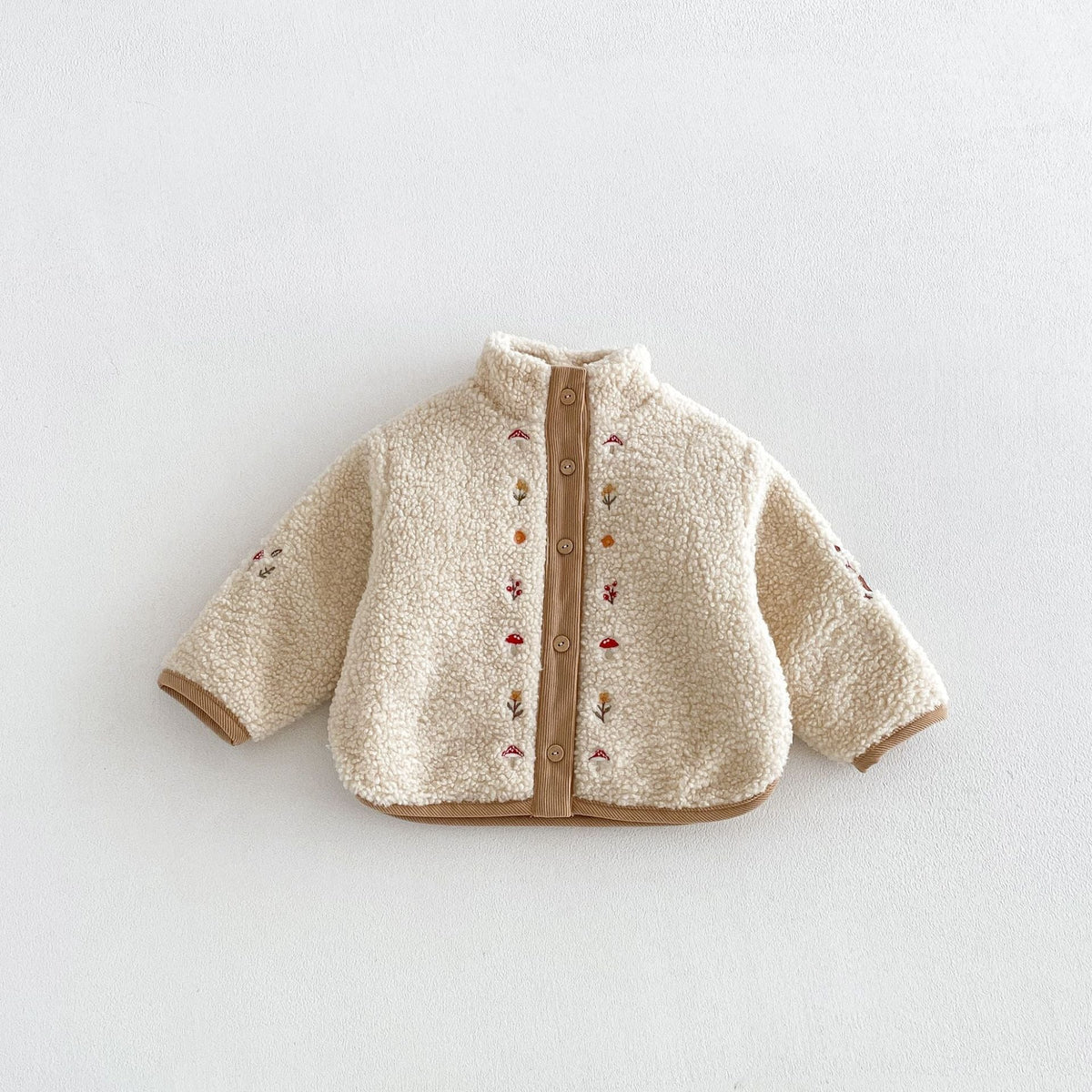 Oatmeal sherpa jacket with embroidered mushrooms and flowers, flat lay