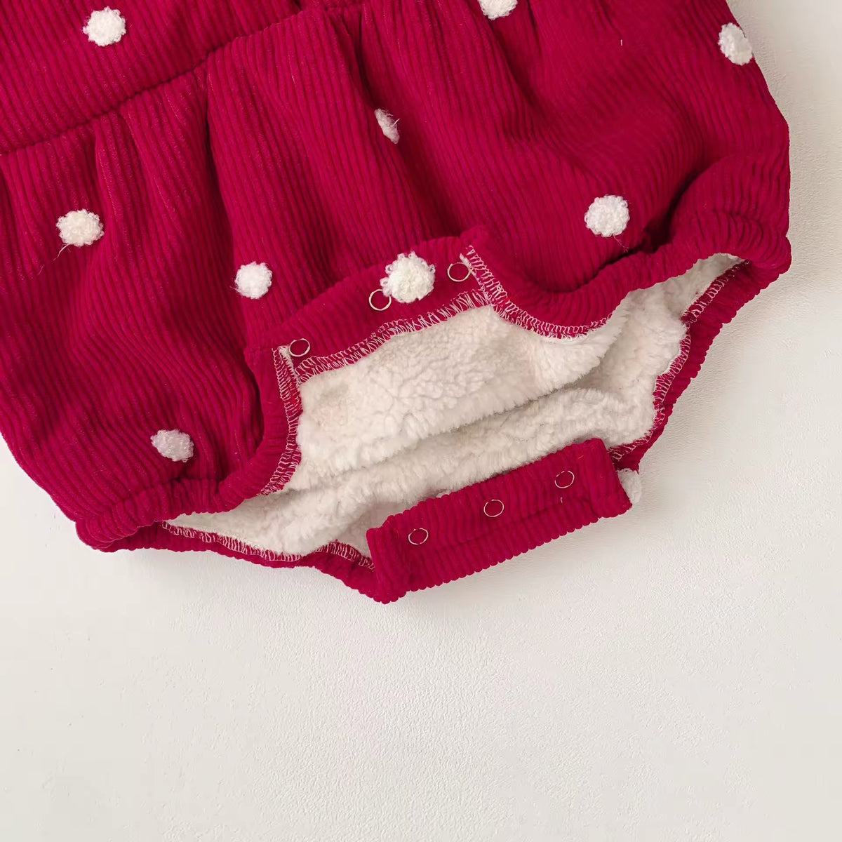 Inside view showing warm fleece lining of red polka dot baby romper