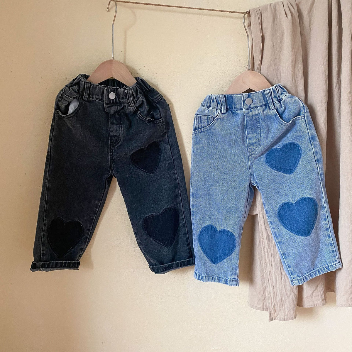 Black and blue heart patch toddler jeans hanging