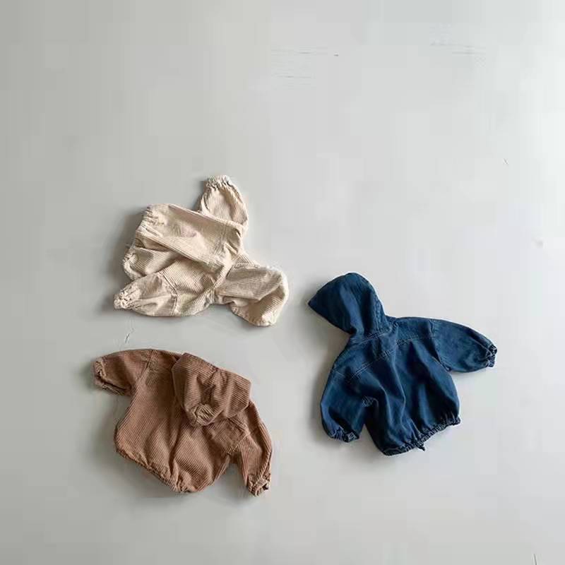 Three small hooded jackets laid flat