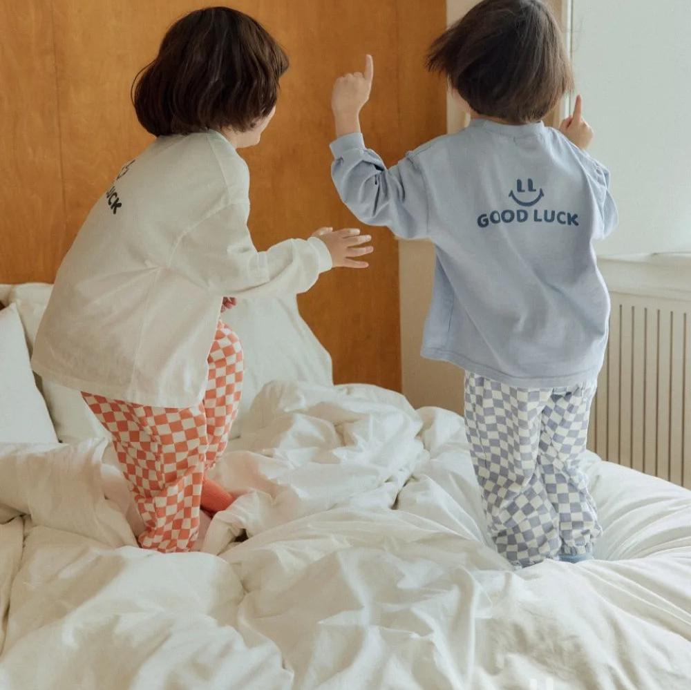 Kids in checkerboard pants, back view