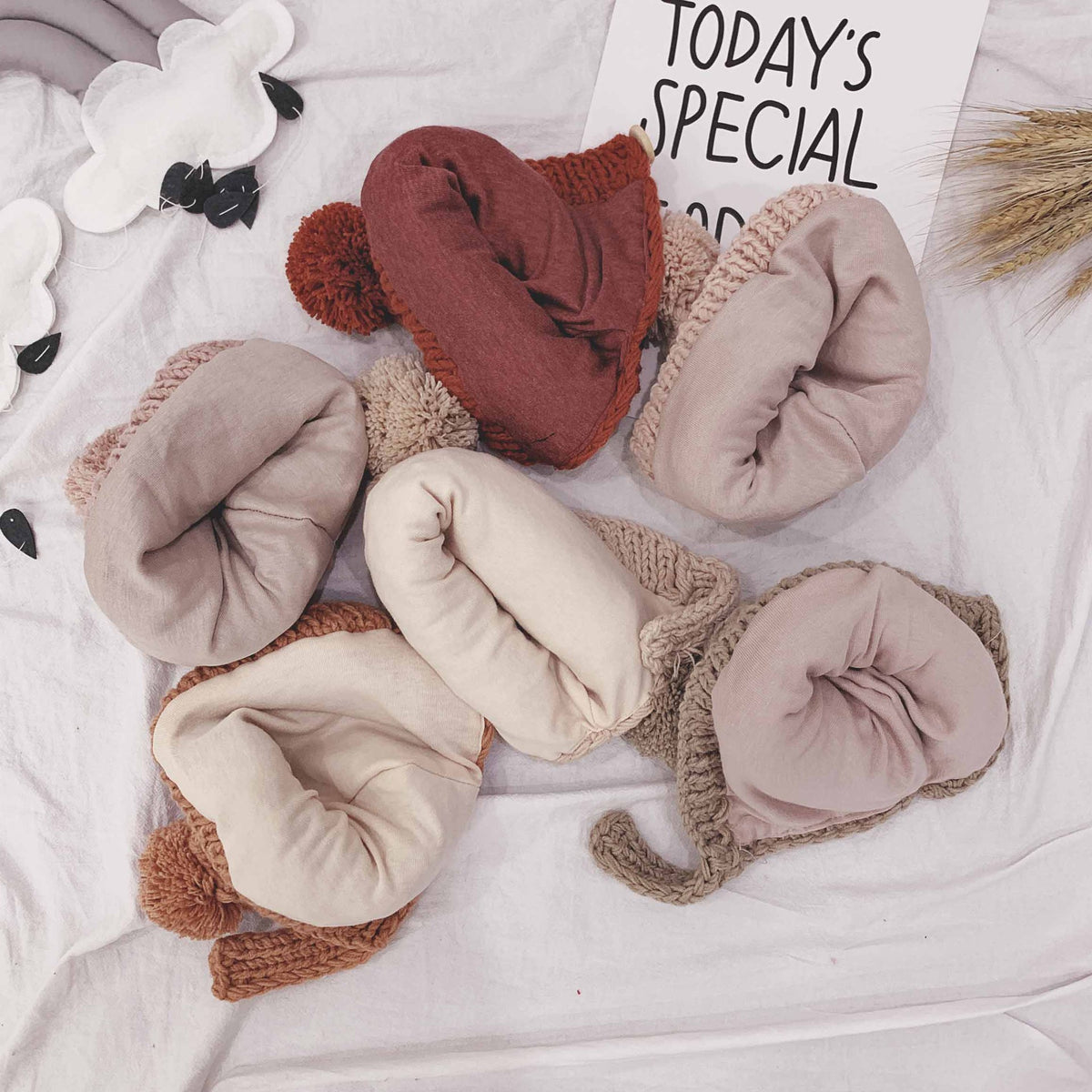 Folded chunky knit baby bonnets in assorted colours