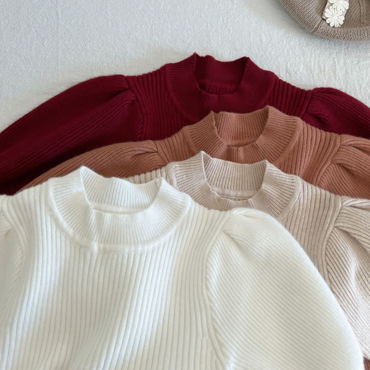 Close-up of knit dress necklines in four colours