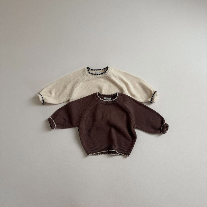 Beige and brown contrast trim knit sweaters laid flat