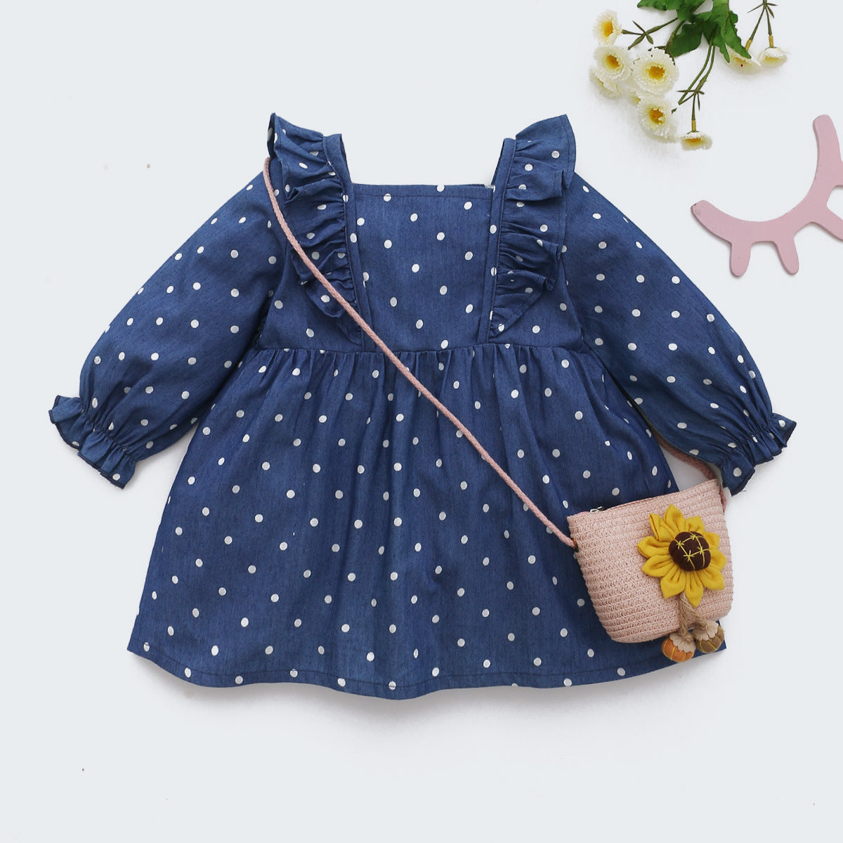 Navy polka dot baby dress with ruffle shoulders and sunflower bag