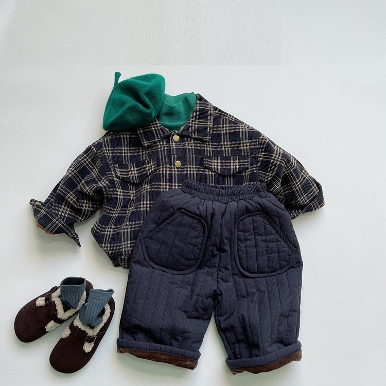 Navy quilted pants styled with plaid jacket and sneakers