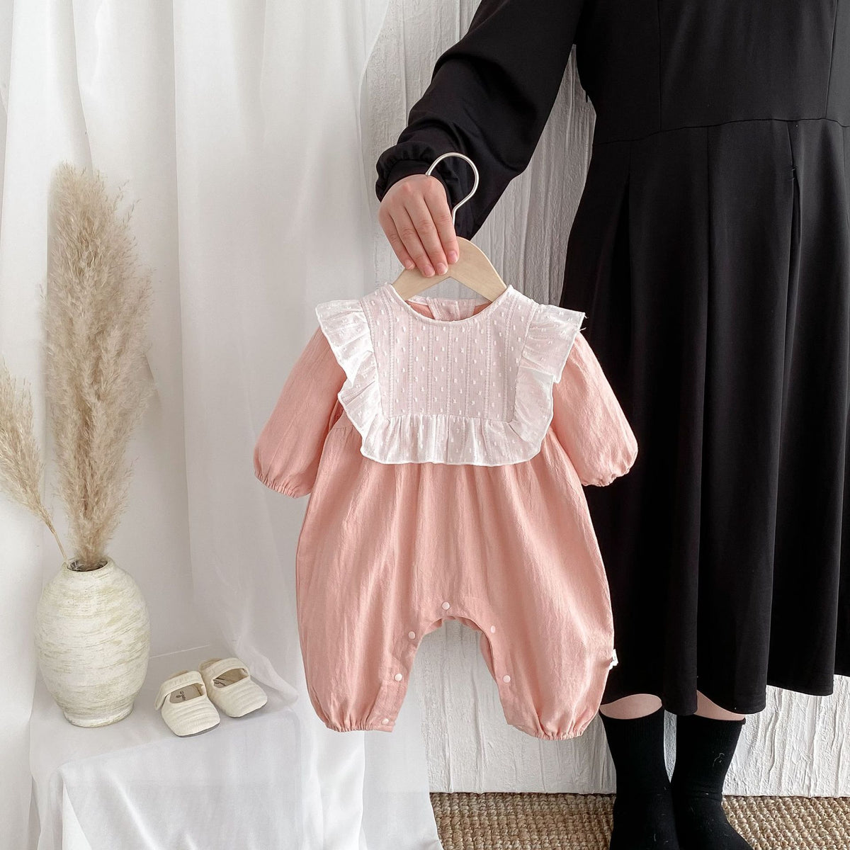 Pink lace collar long sleeve baby romper on a hanger