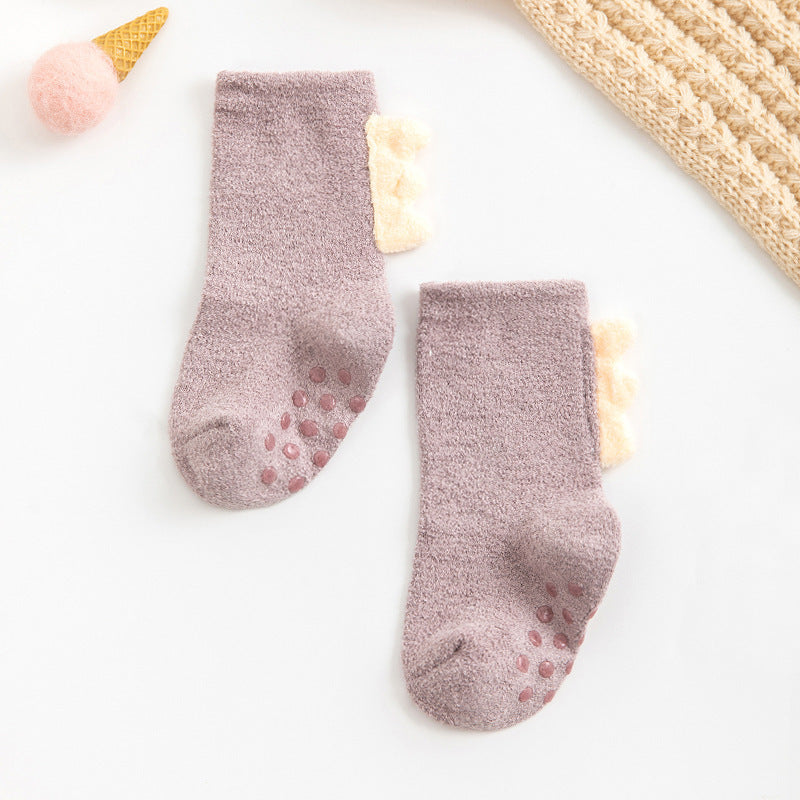 Purple fuzzy baby sleep socks with grips and dino spikes