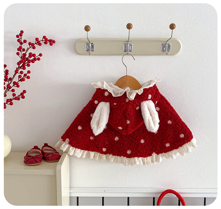 Red baby cape with bunny ears hood hanging on a peg