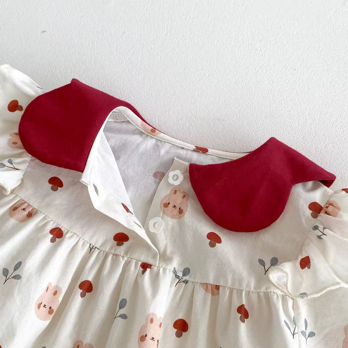 Close-up of red collar and button placket on floral romper