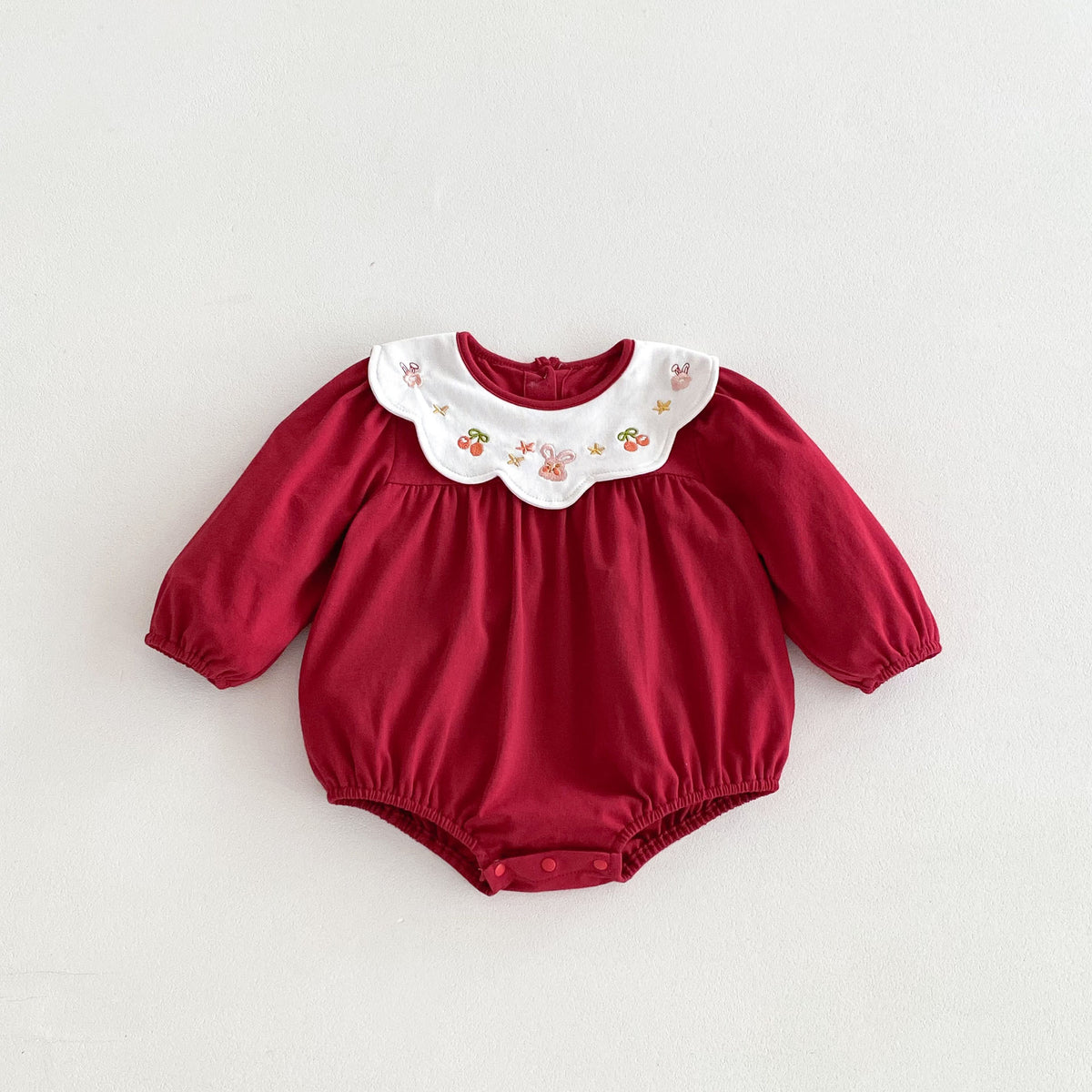 Red cotton bubble romper with embroidered collar on white background