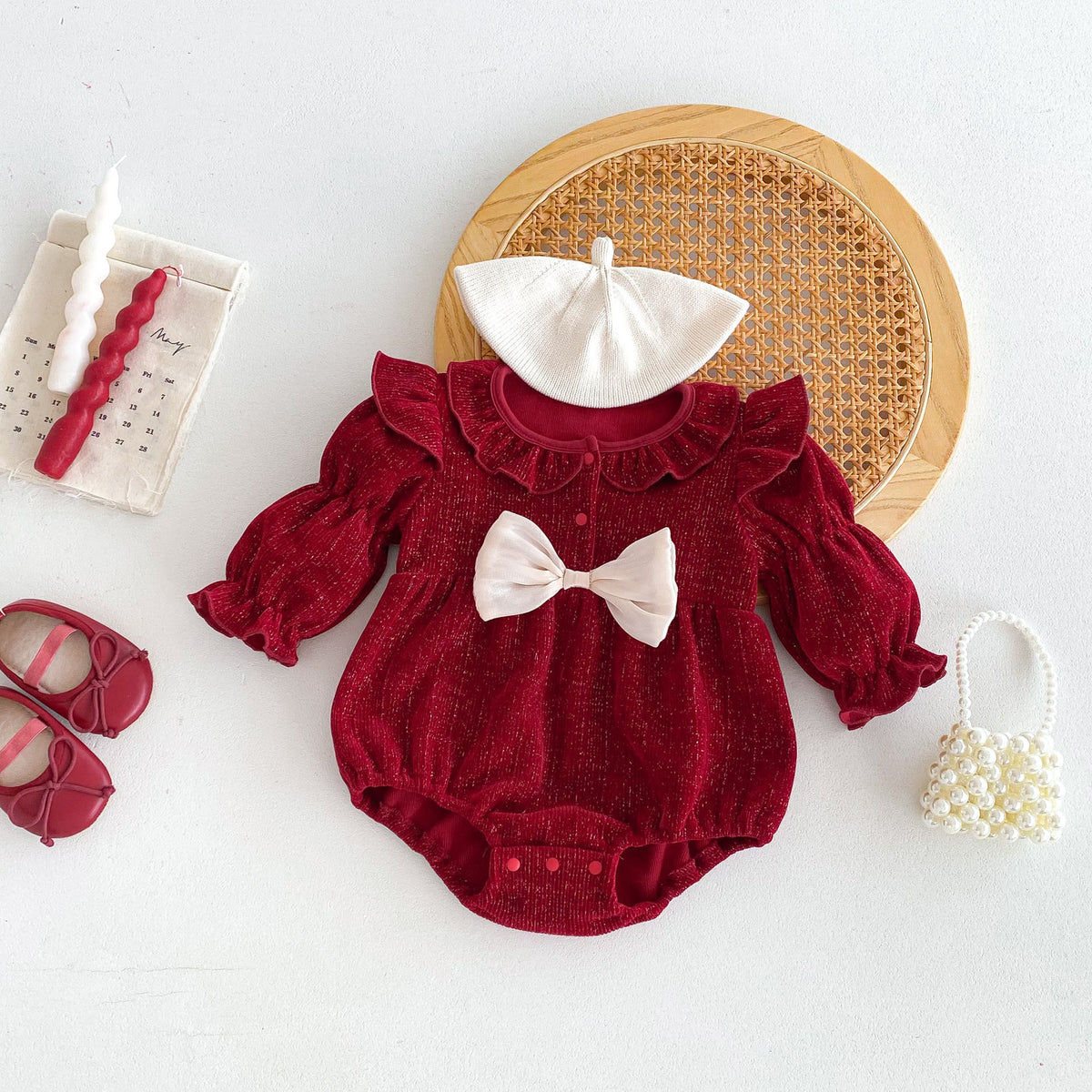 Red ruffle romper with cream hat and pearl bag