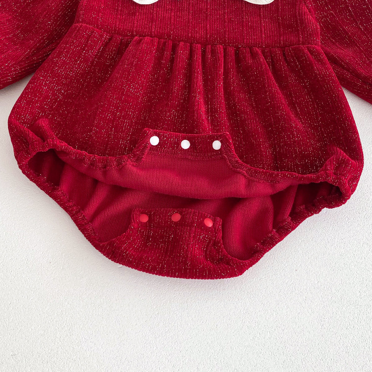 Close-up of snap crotch on red textured baby romper