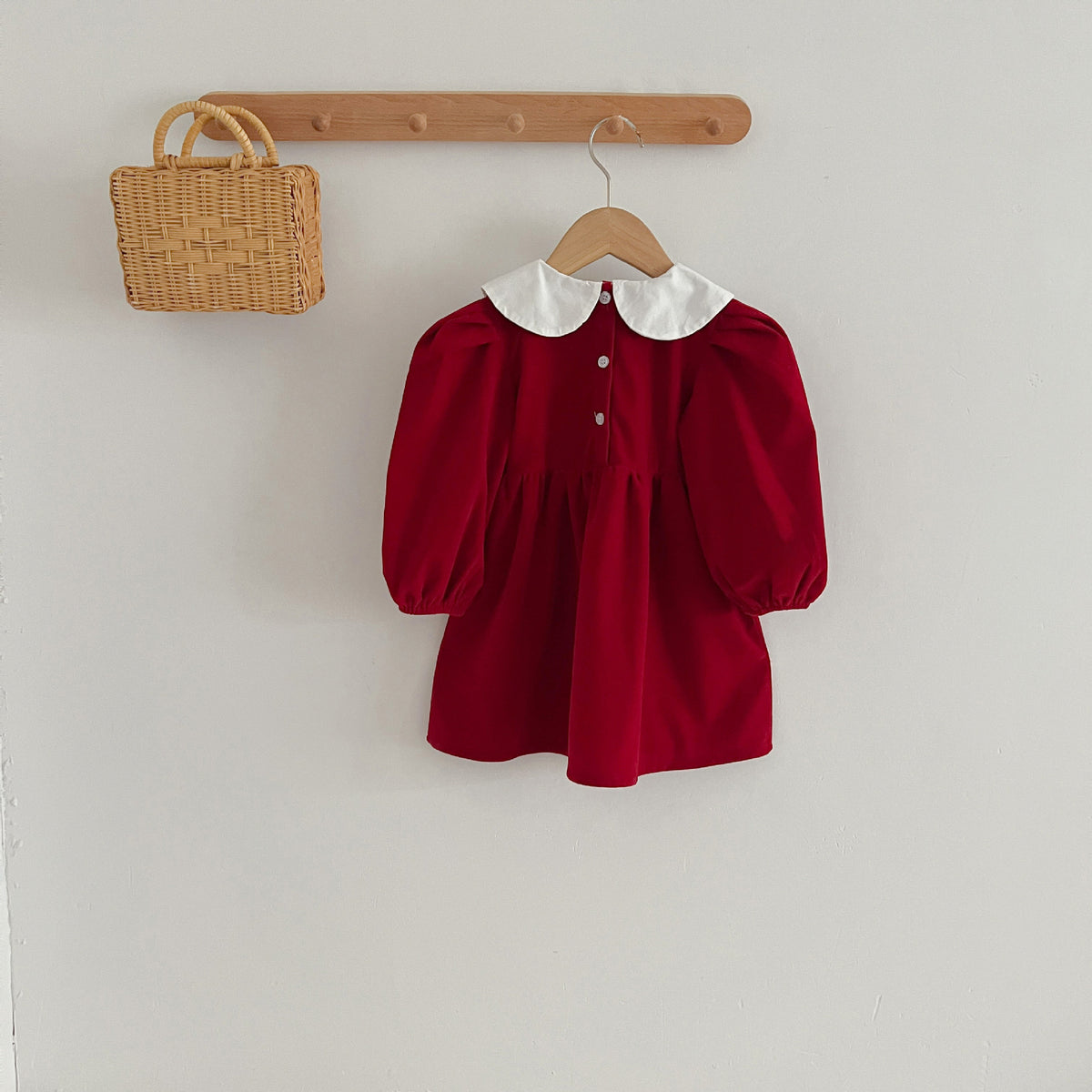 Back view of red smocked dress on a hanger