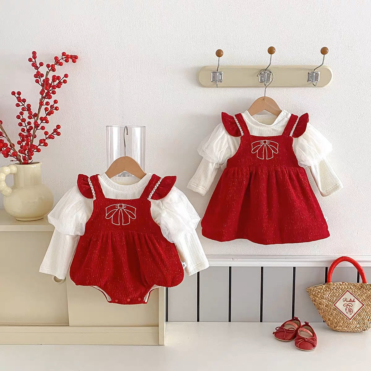 Red sparkle bow romper and dress hanging on wall hooks