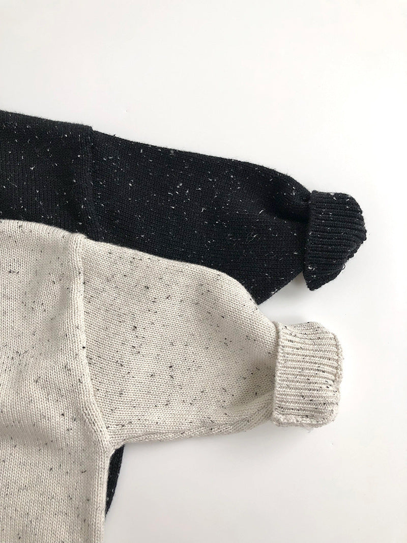Close-up of ribbed cuffs on black and beige sweaters