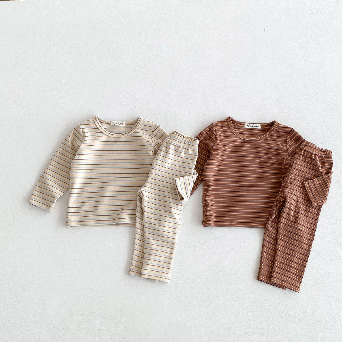 Beige and brown striped pajama sets laid flat