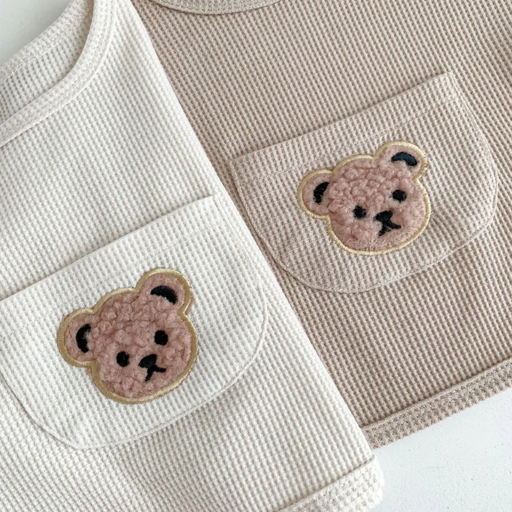 Close-up of fluffy teddy bear patch pockets on waffle fabric