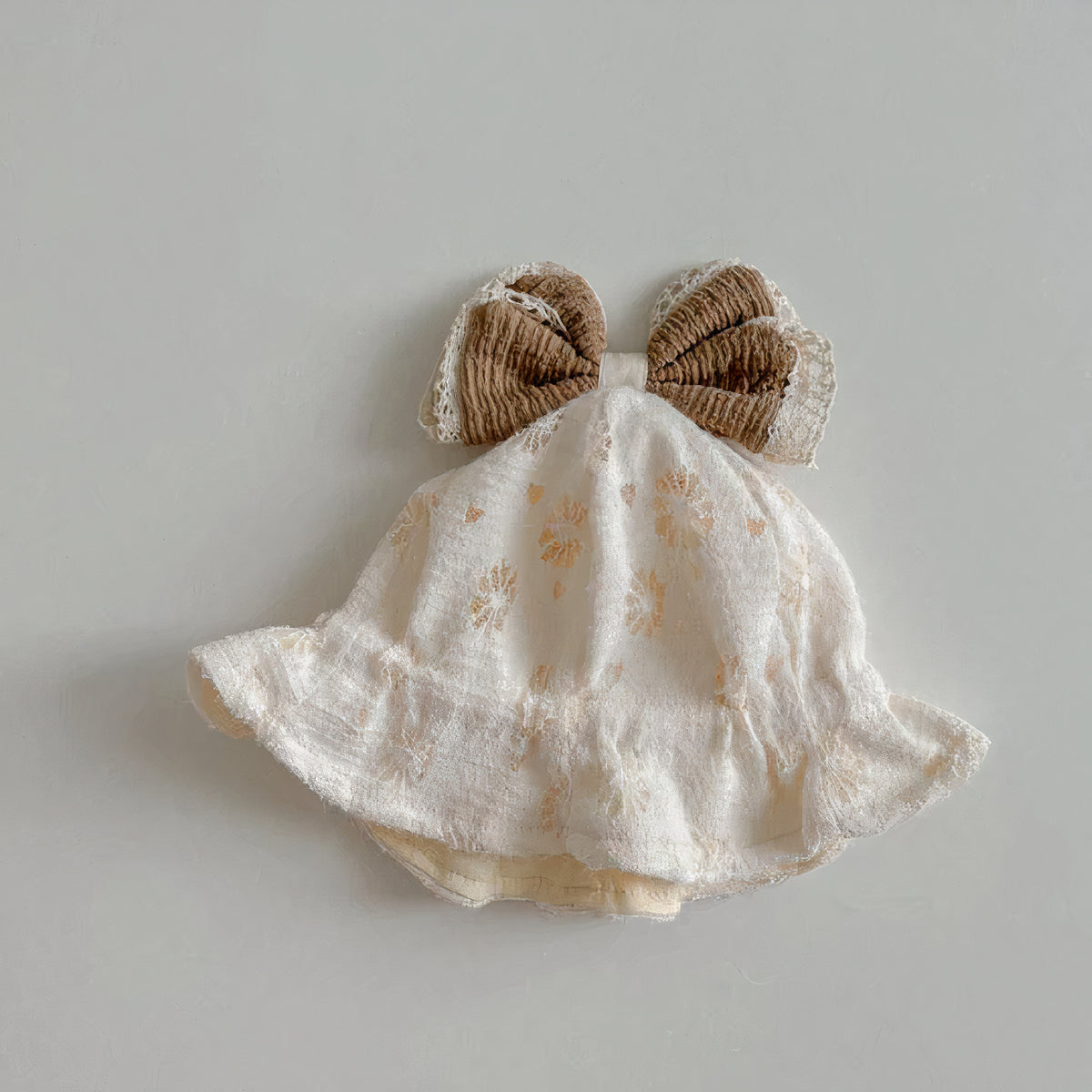 Textured cream baby bucket hat with brown bow