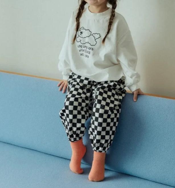 Toddler wearing black checkerboard pants and sweatshirt