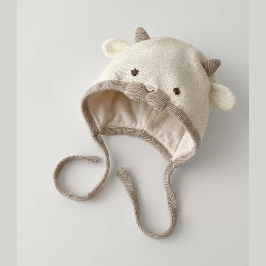 Inside of cream lamb baby bonnet showing soft lining and long ties