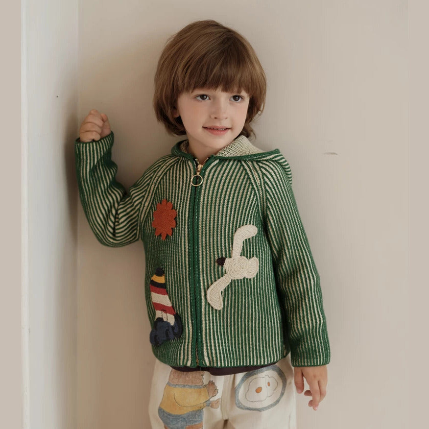 Boy wearing a green striped hooded knit cardigan with lighthouse appliqué