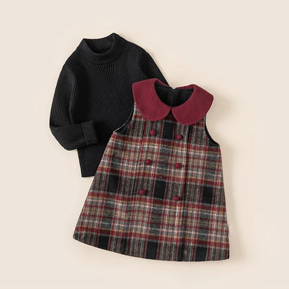 Plaid pinafore dress with black ribbed sweater, girls two-piece set flat lay