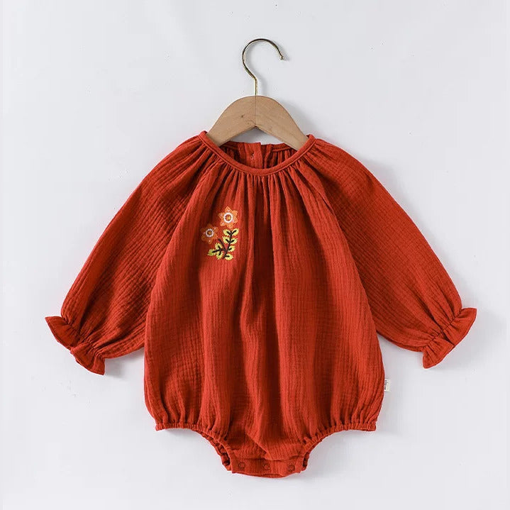 Brick long sleeve gauze baby romper on a wooden hanger