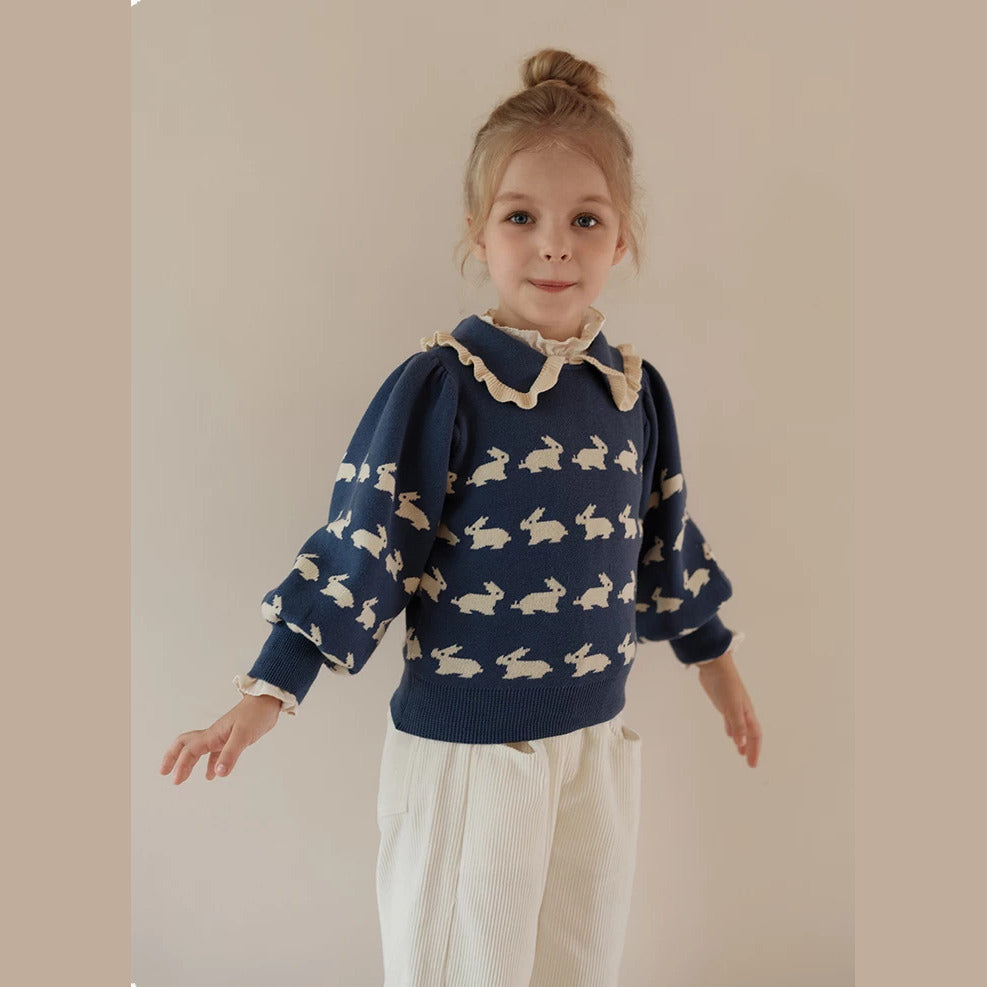 Girl in a navy bunny sweater with puff sleeves