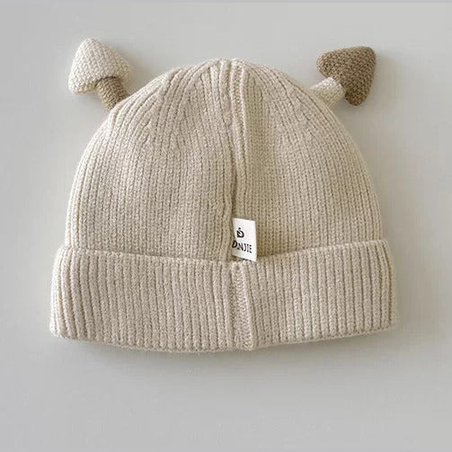 Back view of a cream ribbed knit baby beanie