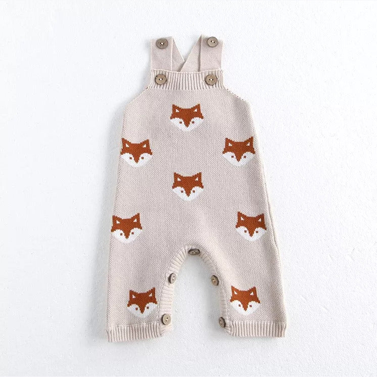 Oatmeal knit baby overalls with an all-over orange fox pattern, flat lay