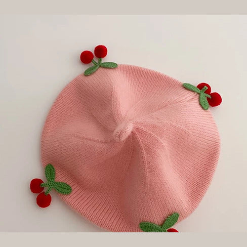 Blush knit baby beret with crochet cherries, flat lay