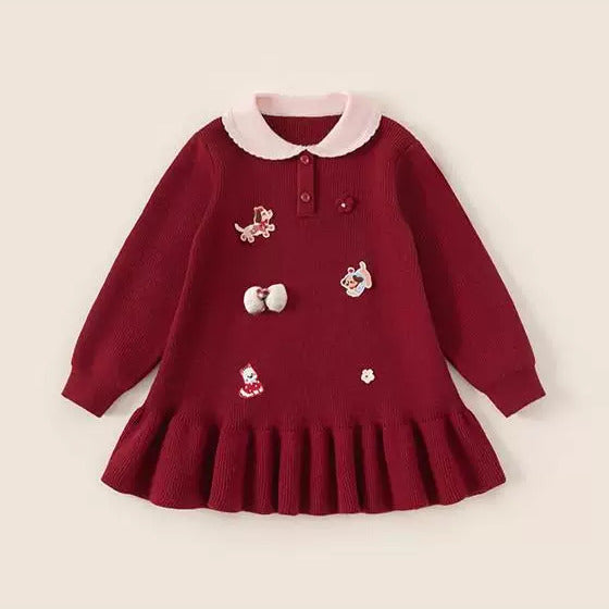 Red knit toddler dress with pink polo collar, embroidered patches and ruffle hem, flat lay