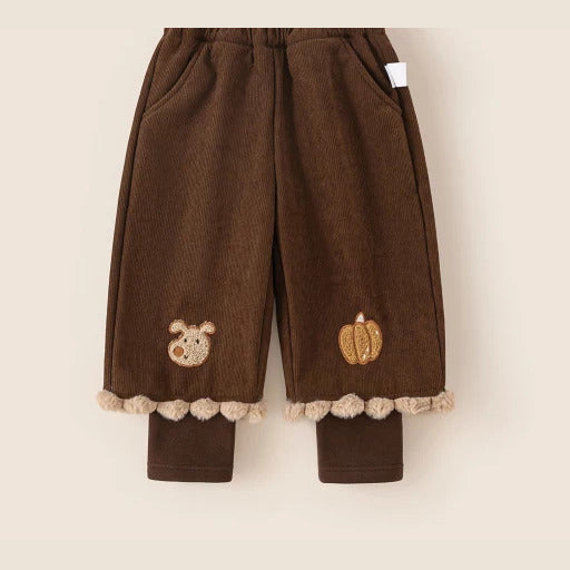 Cocoa brown corduroy girls pants with pompom hem, flat lay