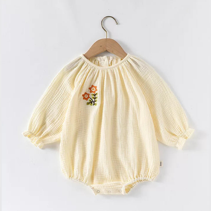 Apricot long sleeve gauze baby romper on a wooden hanger
