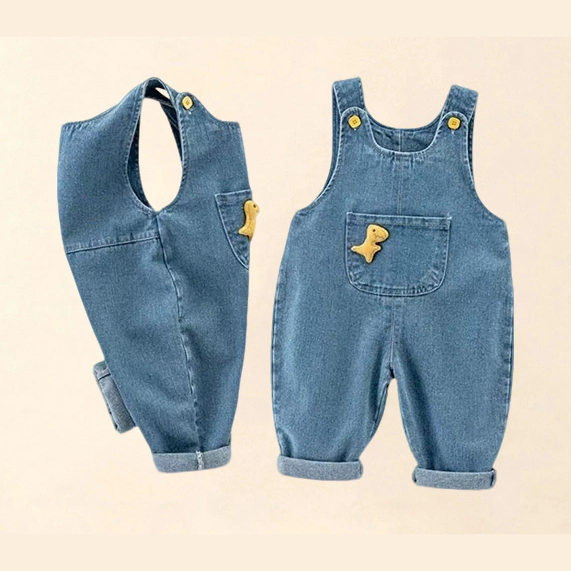 Side and front view of denim overalls with yellow dinosaur appliqué