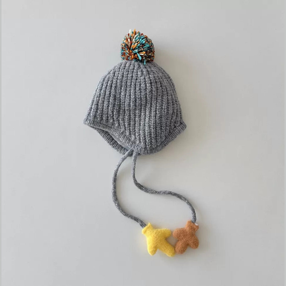 Grey knit earflap beanie for toddlers with multicolour pom-pom and mitten charms