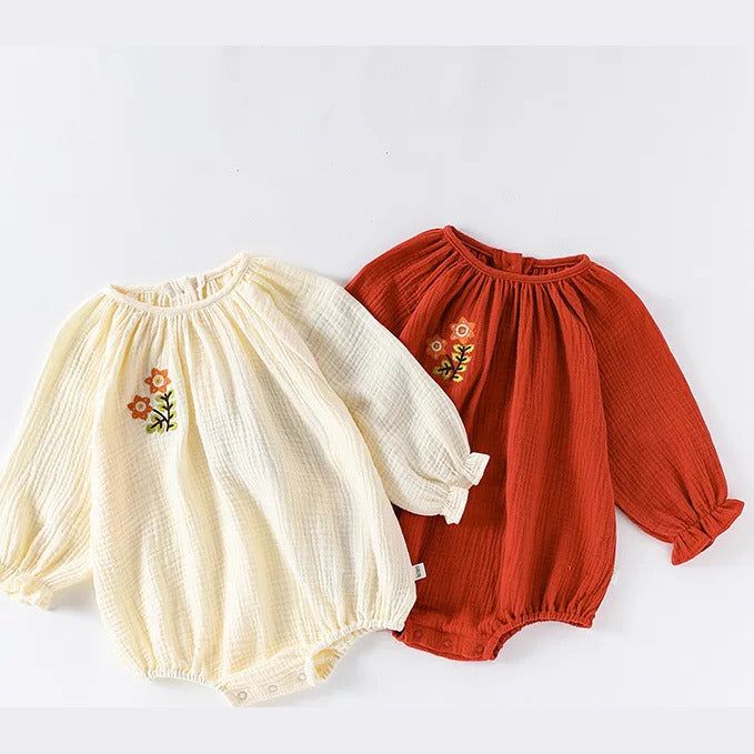 Apricot and brick embroidered gauze baby rompers, flat lay