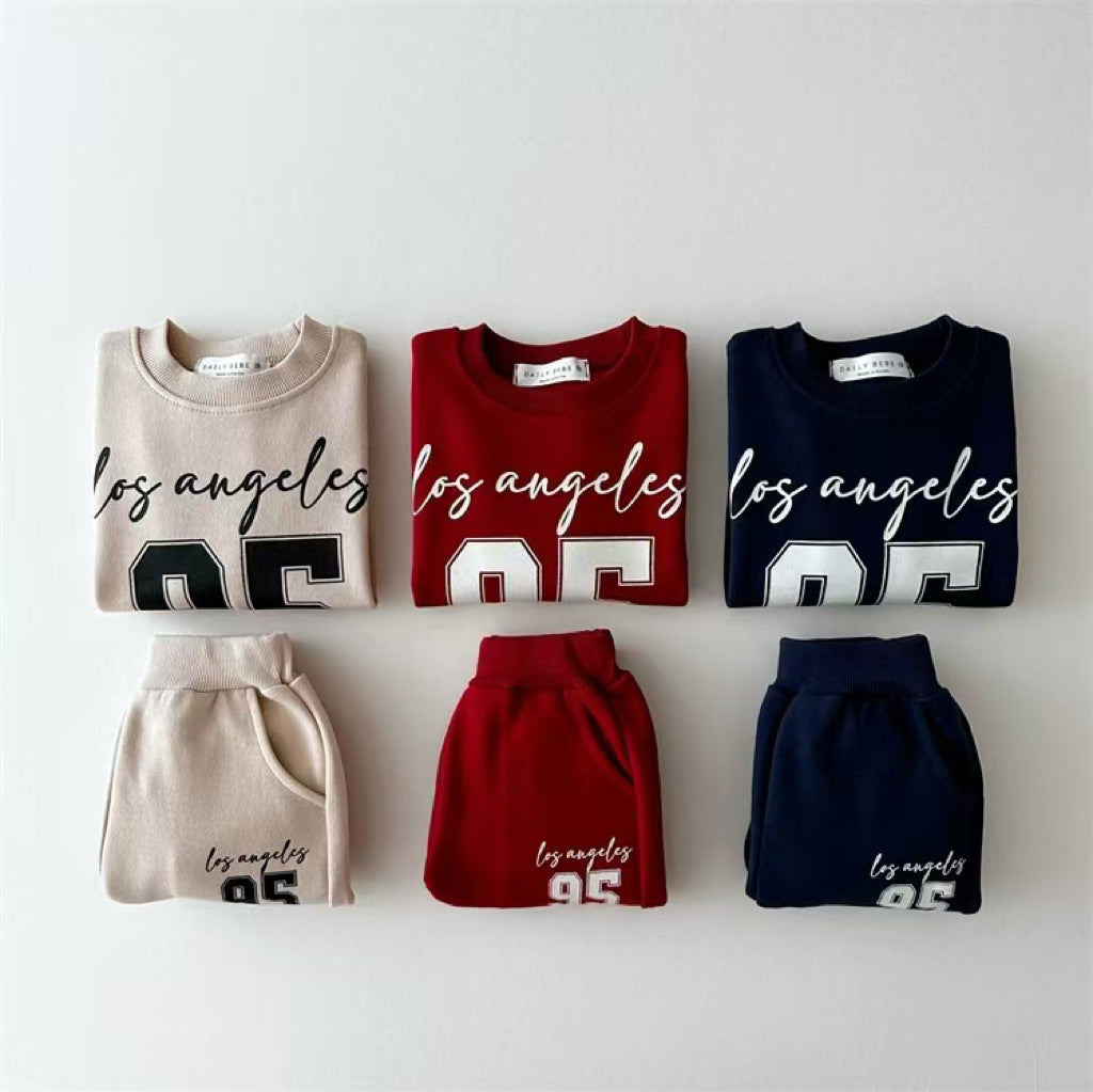 Beige, red and navy varsity 95 sweatshirts and joggers laid flat