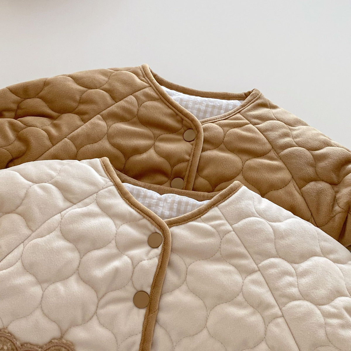 Close-up of wave quilting on apricot and brown baby coats
