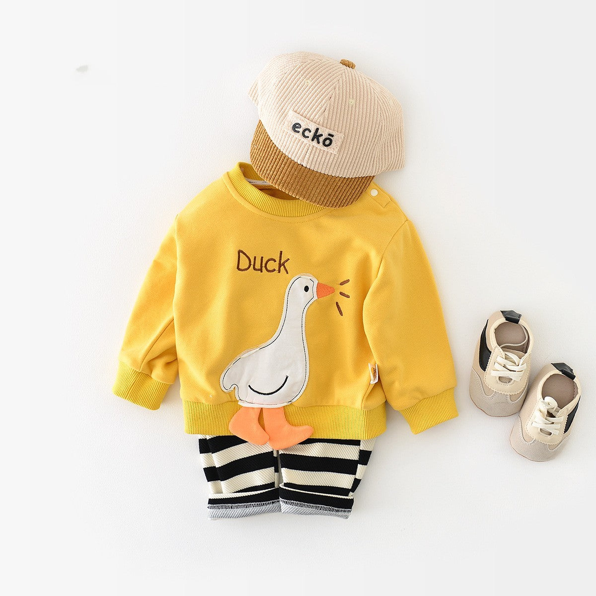Yellow duck sweatshirt styled with striped pants and cap