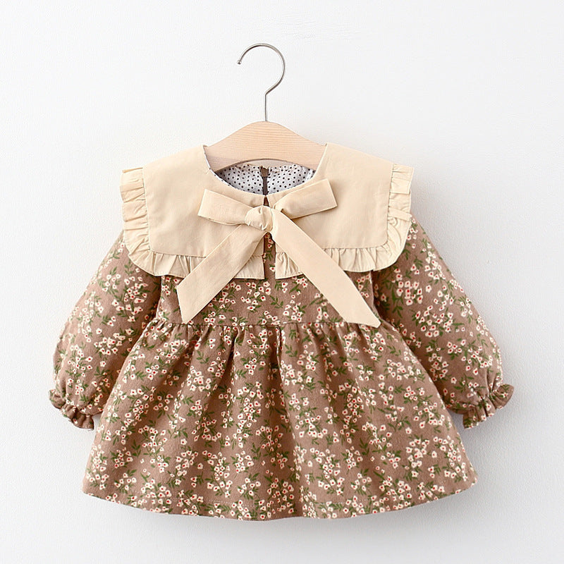 Yellow floral princess dress with cream bow collar on a hanger