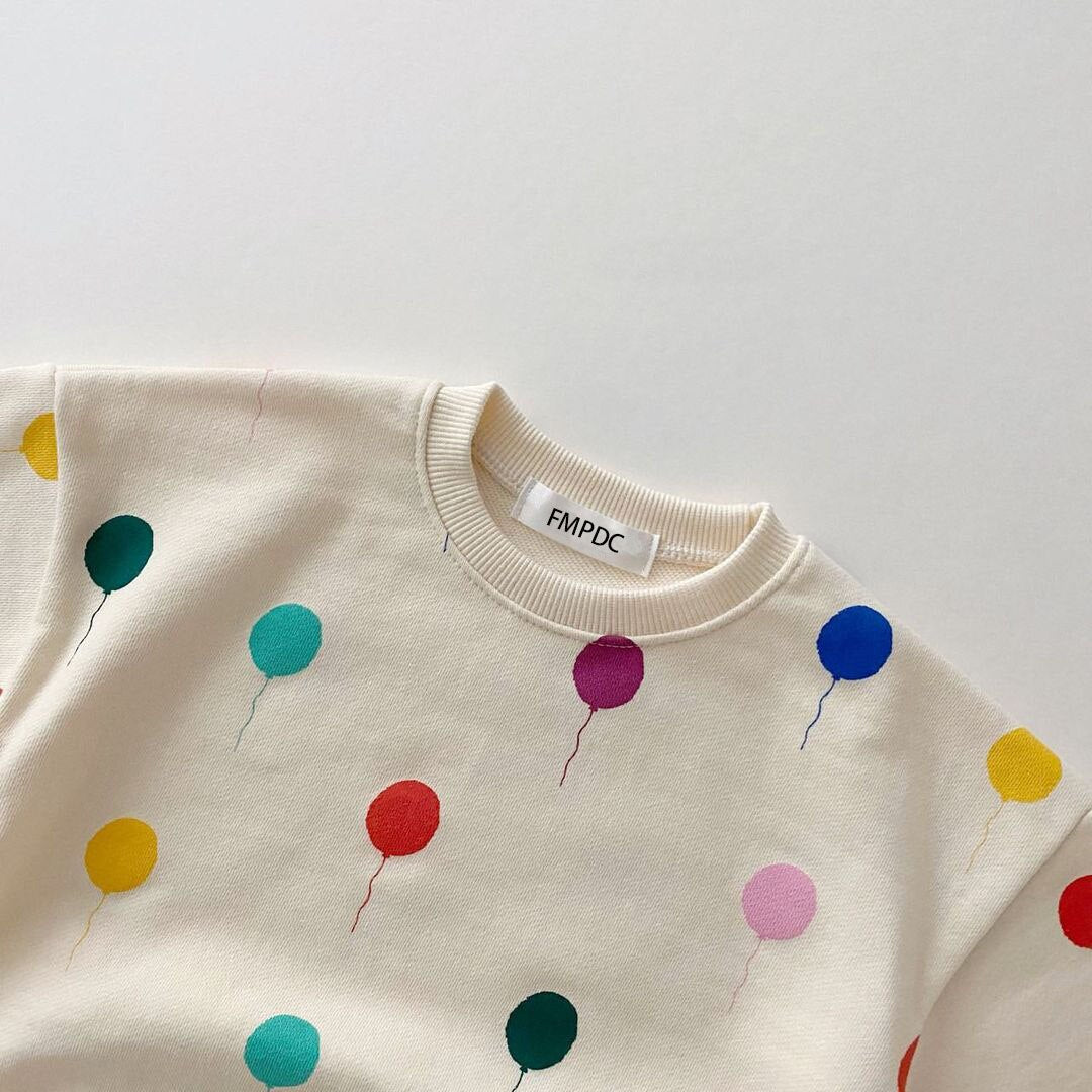 Close-up of colourful balloon print on baby sweatshirt