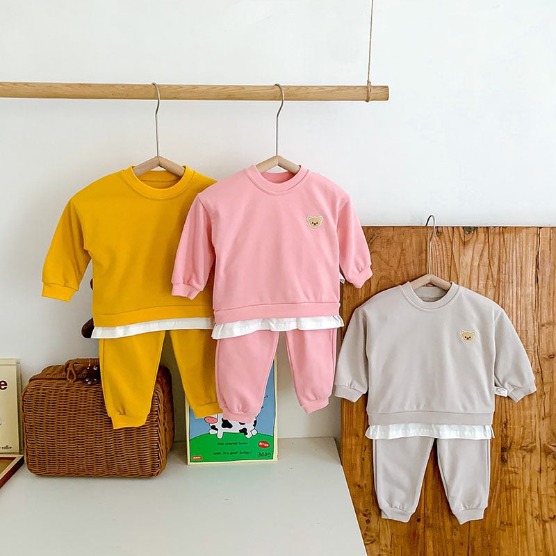 Yellow, pink and grey bear sweatshirt sets on hangers
