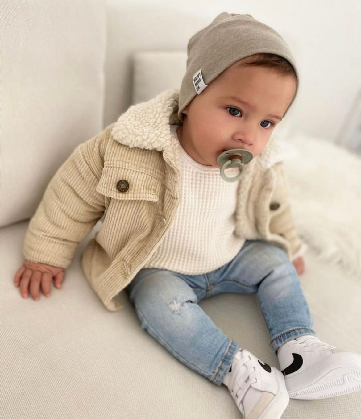 Baby wearing a white corduroy jacket with sherpa collar