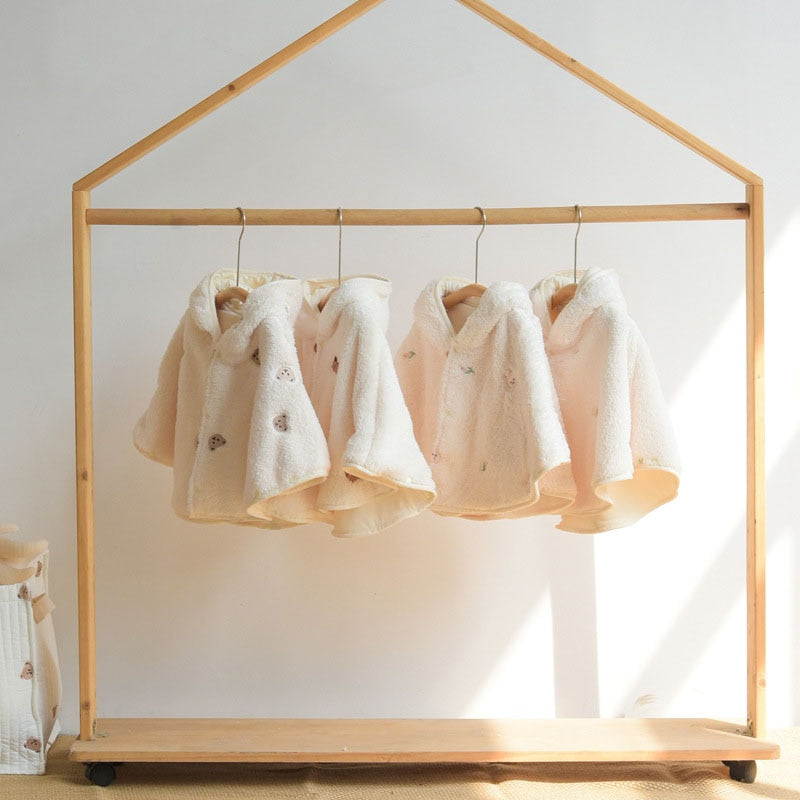 Baby capes hanging on a wooden house rail