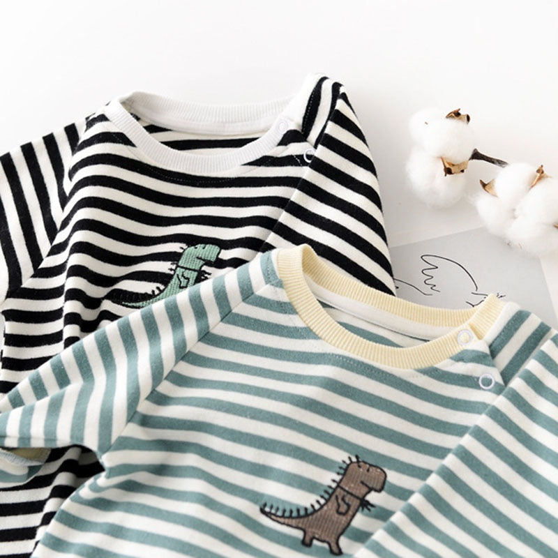 Close-up of dinosaur appliqué on striped baby rompers